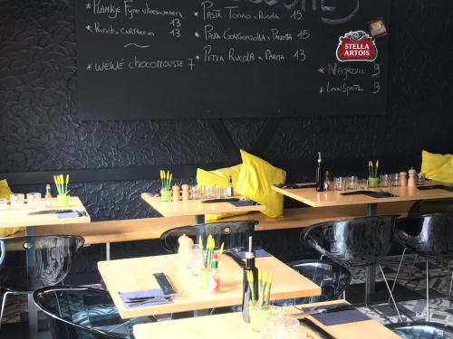 a restaurant with tables and a chalkboard on the wall at James D in De Haan
