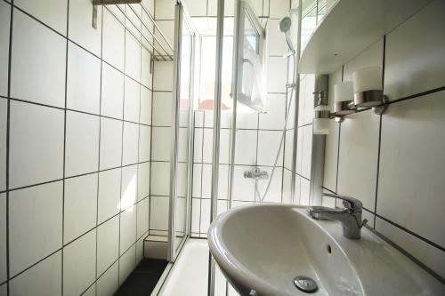 a white bathroom with a sink and a window at Apartment Merklingen in Merklingen