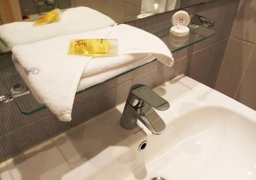 a bathroom with a sink and a towel and a mirror at Oriental Palace Hotel in Manama