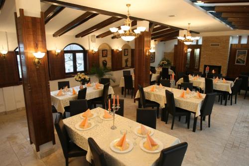 a dining room with white tables and black chairs at Hotel Roco in Izvin