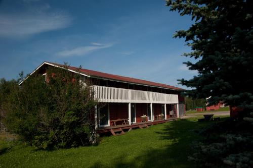 a barn with a red roof on a green field at Paimentupa in Kolinkylä