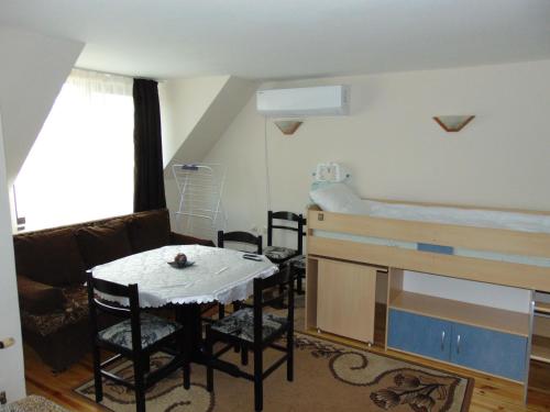 Zimmer mit einem Bett, einem Tisch und Stühlen in der Unterkunft Burgas Central Aleksandrovska in Burgas City