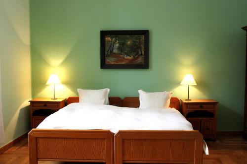 a bedroom with a large bed with two lamps at Gutshaus Gottin in Warnkenhagen