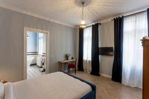 a hotel room with a bed and a bathroom at Little Bucharest mansion next to Parliament Palace in Bucharest
