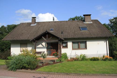 een wit huis met een bruin dak bij Ferienwohnung Schlierbachtal in Lindenfels