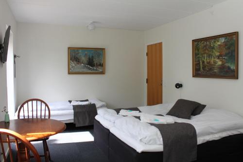 uma sala de estar com duas camas e uma mesa em Lyng Dal Hotel og Restaurant em Ry