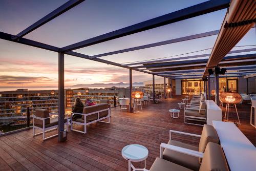 a rooftop deck with couches and tables on a building at Hipotels Playa de Palma Palace&Spa in Playa de Palma