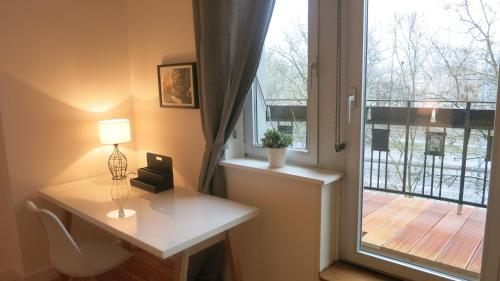 Zimmer mit einem Schreibtisch mit einer Lampe und einem Fenster in der Unterkunft Auster-Appartements in Saarbrücken