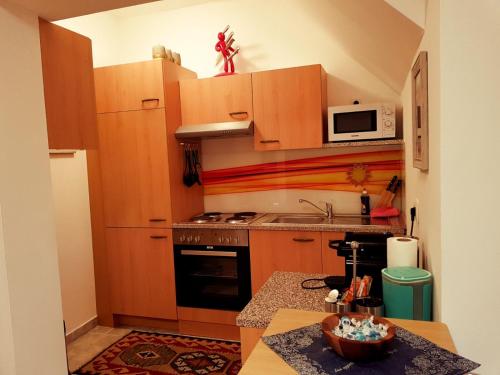 a kitchen with wooden cabinets and a stove top oven at Ferienwohnung Eckberger Weinstrasse 139 in Gamlitz