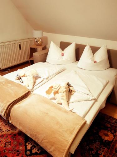 a large bed with white sheets and pillows at Ferienwohnung Eckberger Weinstrasse 139 in Gamlitz