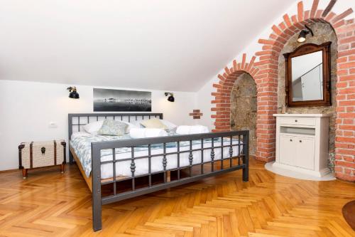 a bedroom with a bed and a brick wall at Old Split Apartment in Split