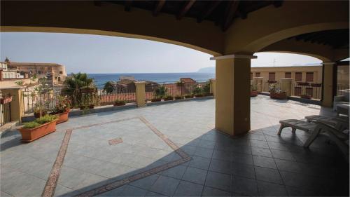 an outdoor patio with a view of the ocean at Hotel La Piazzetta in Castellammare del Golfo