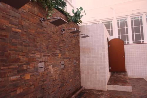 a bathroom with a brick wall with a urinal at Gran Hotel Balneario de Liérganes in Liérganes