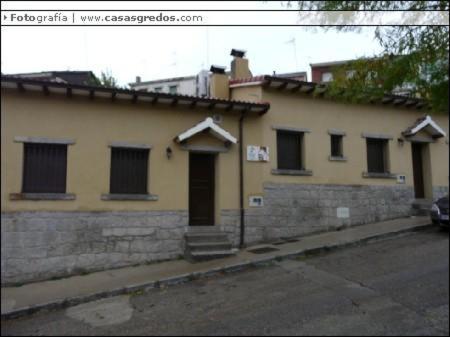 a yellow building with windows and a door on a street at Casa Rural las Escuelas II in Hoyo de Pinares
