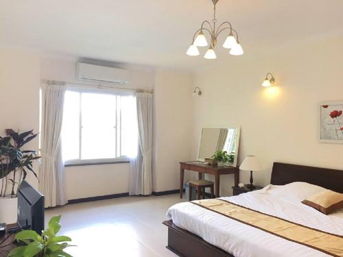 a bedroom with a bed and a window and a mirror at Vietnam Golf - Lake View Villas in Ho Chi Minh City