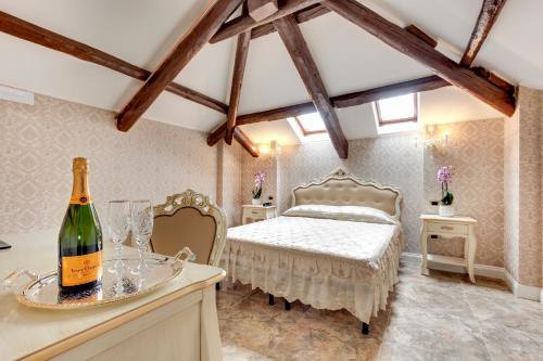 una camera con letto e una bottiglia di vino di New Reiter Hotel a Lido di Venezia
