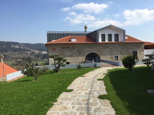 a house with a stone pathway leading to a building at Hotel Rural Quinta das Quintães in Penafiel