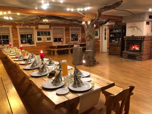 a long table in a large room with a tree at Tihuse Horsefarm B&B in Liiva