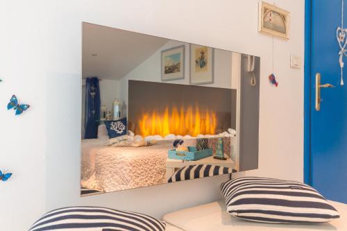 a bedroom with a bed with a fire in a mirror at Blue Sea Apartment by Locap Group in Piran