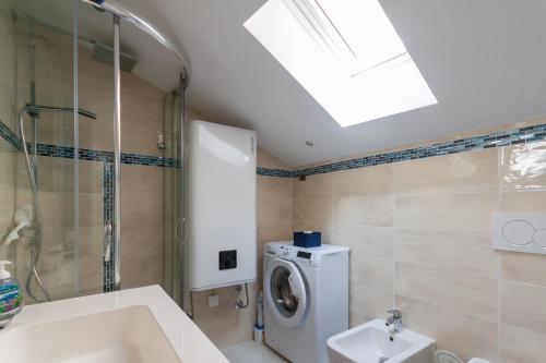 a bathroom with a sink and a washing machine at Blue Sea Apartment by Locap Group in Piran