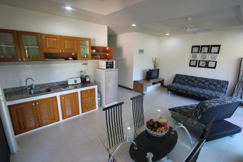 a kitchen and a living room with a couch and a table at Babylon Pool Villas in Nai Harn Beach