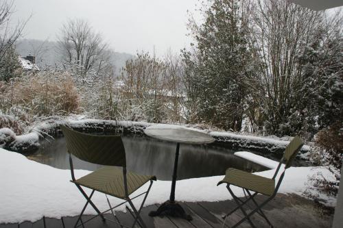 two chairs and a table in the snow at N1 Standalone House Baden in Nussbaumen