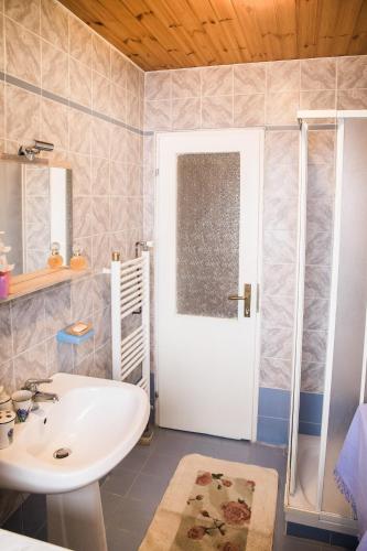 a bathroom with a white sink and a shower at Počitniška hiša Pologar in Tolmin