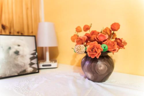 a vase with flowers on a table next to a picture of a dog at Počitniška hiša Pologar in Tolmin