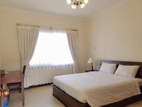 a bedroom with a large bed and a window at Vietnam Golf - Lake View Villas in Ho Chi Minh City