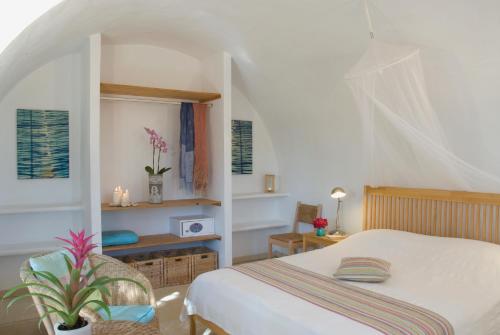 Un dormitorio con una cama y una mesa con una planta en El Jardín de los Sueños en Rodalquilar