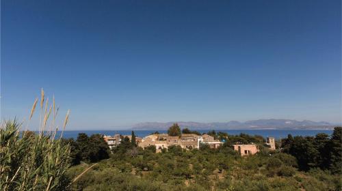 a house on a hill with the ocean in the background at Hotel La Piazzetta in Castellammare del Golfo