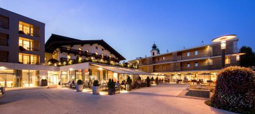 a building with tables and chairs in a courtyard at Hotel Wirtshaus Post in Sankt Johann in Tirol