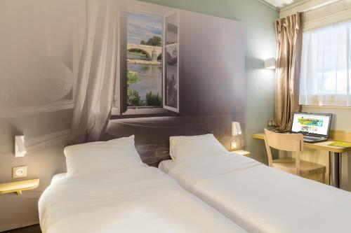 Un pat sau paturi într-o cameră la B&B HOTEL Brignoles