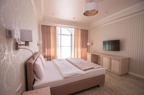 a hotel room with a bed and a television at Hotel Cheluskintsev in Gagra