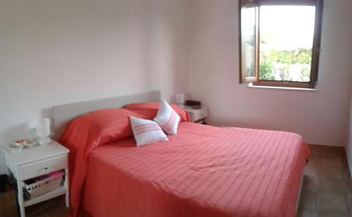 a bedroom with a red bed with a window at monte moro in Arzachena