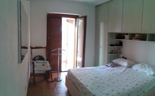 a bedroom with a bed and a chair and a window at monte moro in Arzachena