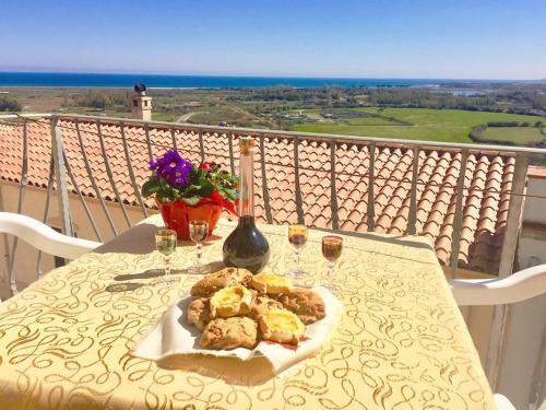 een tafel met een bord eten en een glas wijn bij Casa Angelina-Ammentos Posada in Posada