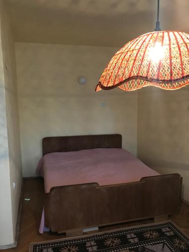 a bedroom with a bed with a large lamp at Labris apartment in Kyustendil