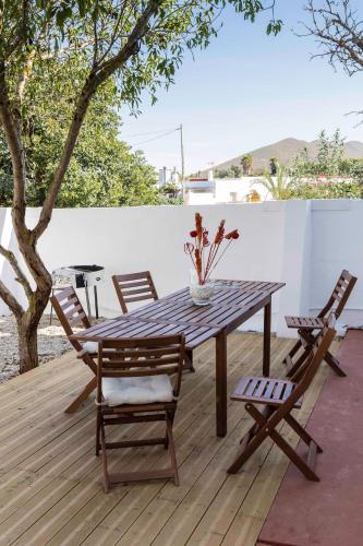 a wooden table and chairs on a wooden deck at Mdina in Fernán Pérez
