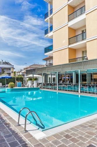 a large swimming pool in front of a building at Hotel Imperial in San Benedetto del Tronto