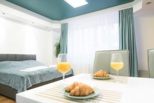 a bedroom with a bed and a table with two glasses of orange juice at Apartma City & Free Parking in Ljubljana