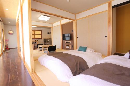 En eller flere senge i et værelse på Tabinoteitaku Okinawa Nakijin HOMANN CONCEPT