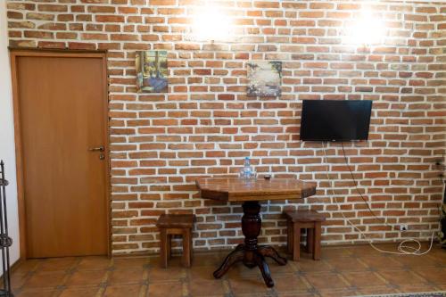 a brick wall with a table and a television on it at Fortetsya "Стабільне електропостачання!" in Umanʼ