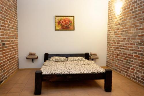 a bed in a room with a brick wall at Fortetsya "Стабільне електропостачання!" in Umanʼ