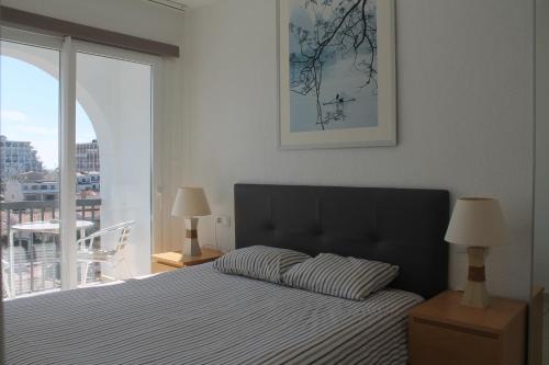エンプリアブラバにあるAbsolute Apartmentのベッドルーム1室(ベッド1台、大きな窓付)