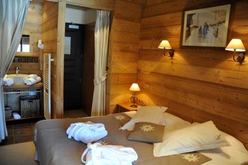 a bedroom with a bed with towels on it at Hôtel Chalet Alpage in La Clusaz