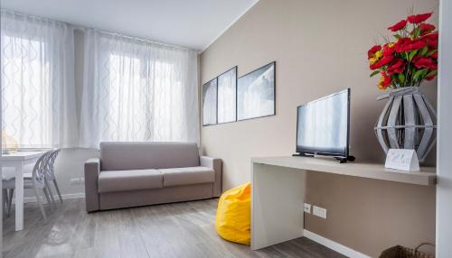 a living room with a chair and a vase of flowers at Italianway-Cadorna 10A Flat in Milan