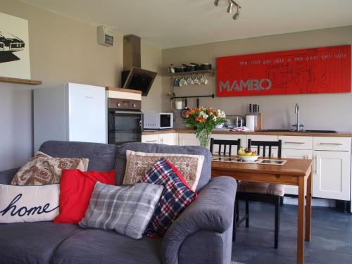 een woonkamer met een bank en een tafel met kussens bij The Studio in Georgeham