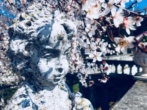 a statue of a boy with flowers on a tree at Charme of Villa Capannina in Novi Ligure