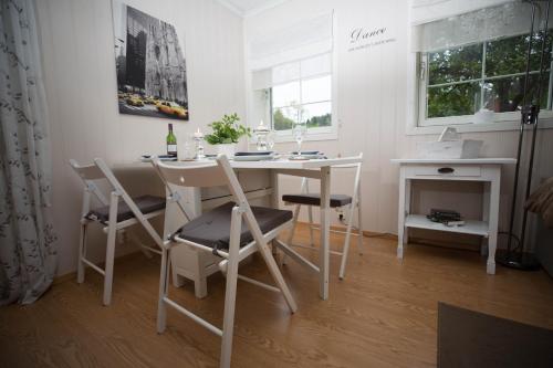a white dining room with a table and chairs at Apartment at Ranheim in Trondheim